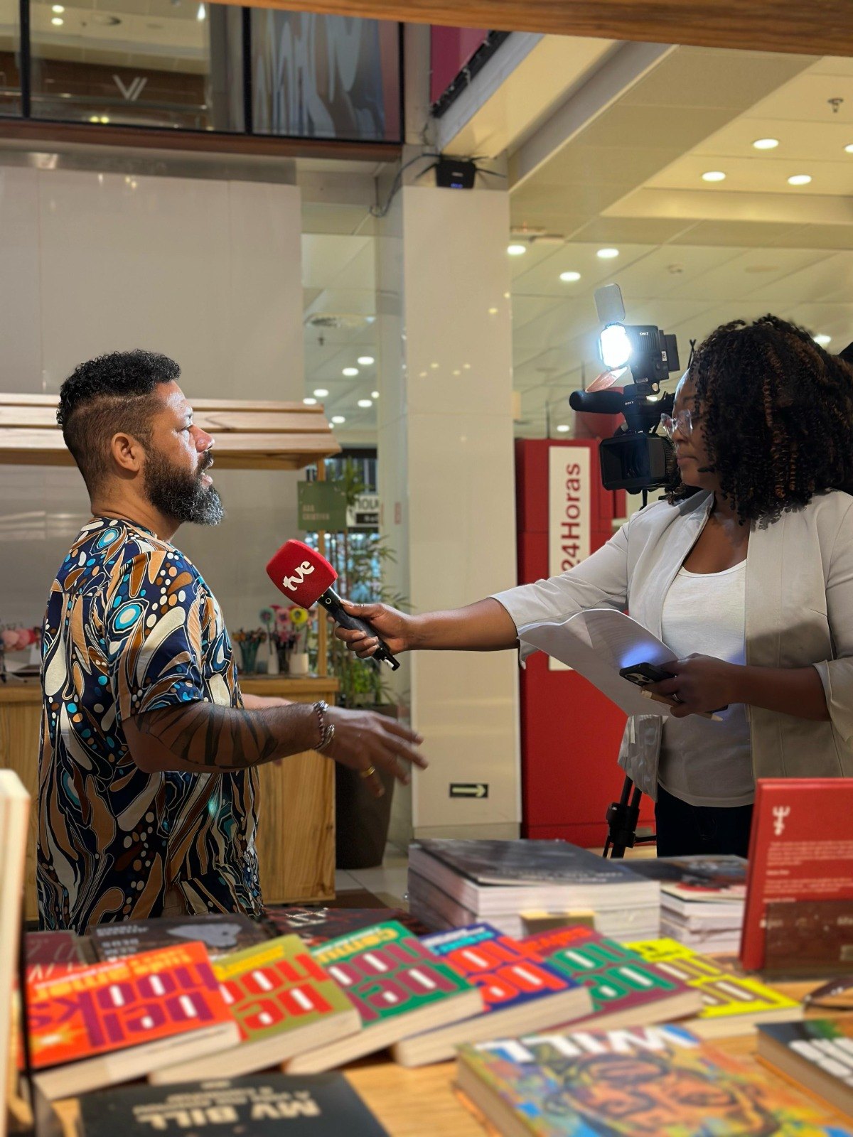 Zé Ricardo Ferreira em entrevista ao lado de livros